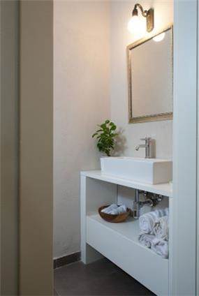 חדר אמבטיה מעוצב בסגנון כפרי בצבעוניות בהירה. Niego Design