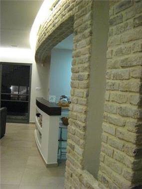 קיר אבן פירוק מתעגל בסלון-אדריכלית, שגית גולדשמידט