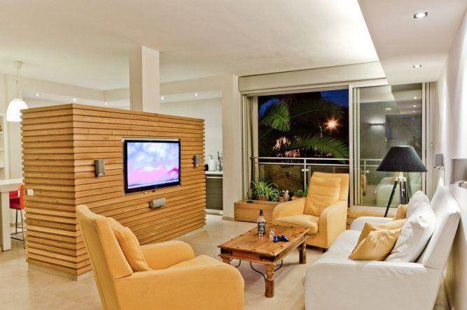 סלון דירה בבבלי המשלבת קיר טלוויזיה מעץ. עיצוב: שמרית קאופמן