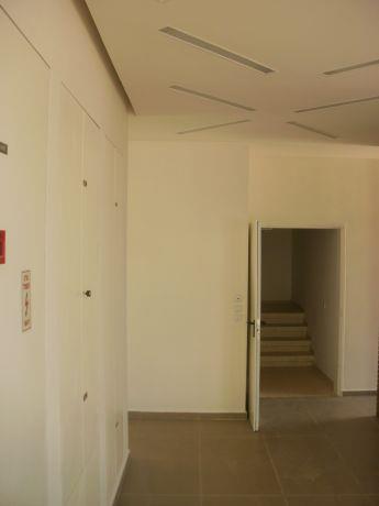 מבט אל מבואה המובילה אל חדר מדרגות בבניין מגורים,בעיצוב נקי וחלק של האדריכל יניב סולומון