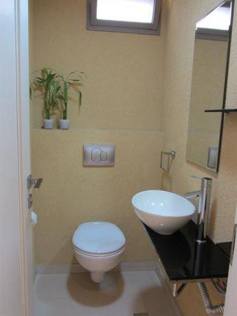 חדר אמבטיה מעוצב בסגנון מודרני הכולל אסלה תלויה וכיור מונח. עיצוב: מגי דוידוב