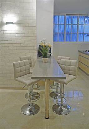 פינת אוכל בסגנון מודרני המורכבת משולחן בר וכסאות גבוהים. עיצוב: i.m design