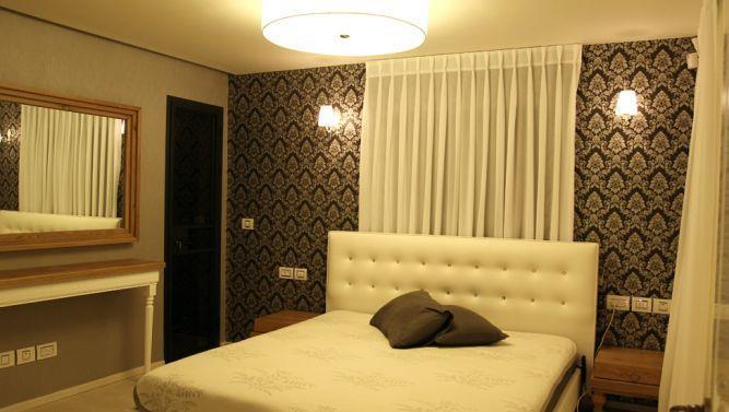 חדר שינה בגווני אפור ולבן עם שילוב של עץ אגוז, עיצוב mind אדריכלים
