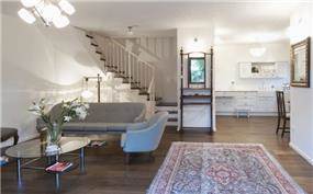 מבט אל הסלון והמטבח בקוטג' בן שלושה מפלסים בבית דגן - תכנון וביצוע ע''י הילה לוסקי