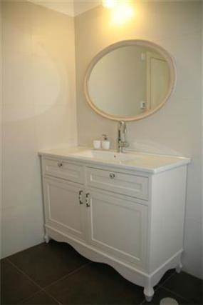 מבט אל חדר אמבטיה בעל מראה גדולה בעיצוב קלאסי נקי של מרב פלגי