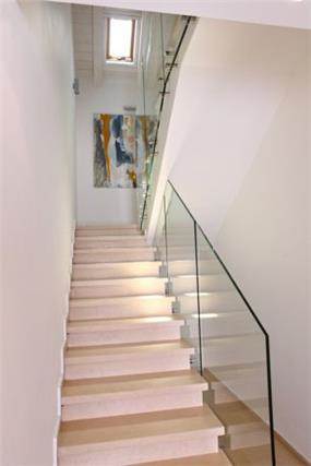 מדרגות עם מעקה זכוכית נקי ללא ידית. עיצוב: סיגל לנמן סוקול