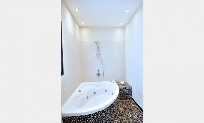 חדר אמבט מעוצב בדירתו של ליאור סושרד בדגש על פסיפס אבנים שחורים  בתכנון ועיצוב של קרן רוזנר