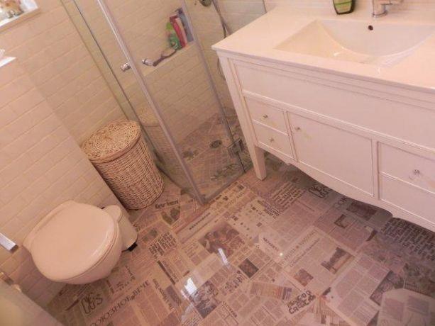 מבט אל חדר אמבטיה המרוצף בדוגמת גזרי עיתונים. עיצוב: אופן ספייס