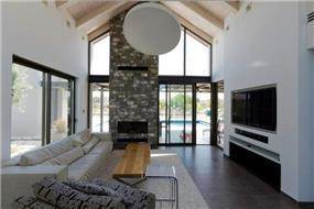 קיר בריקים גדול ותקרה עם קורות חשופות בסלון, עיצוב: Saab Architects 
