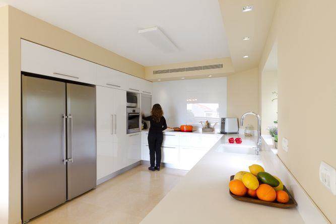 מטבח לבן בשילוב קיר הצבוע בגווני מוקה,  עיצוב Saab Architects 
