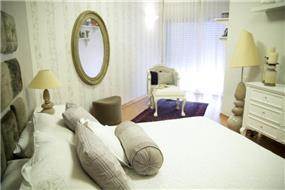מבט צד לחדר שינה מעוצב בקו נקי תוך כדי הקפדה על הפריטים הקטנים בסגנון וינטאג' בעיצוב ותכנון של ג'ני דיין