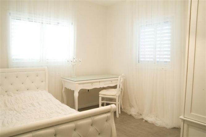 חדר שינה במראה קלאסי על טהרת גווני הלבן בעיצוב ותכנון של ג'ני הום סטיילינג