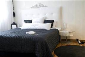 חדר שינה בעל מיטה בשילוב קפיטונאג' למראה יוקרתי בעיצוב ותכנון של ג'ני דיין