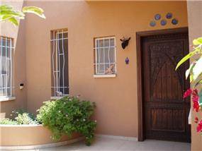 דלת כניסה בסגנון מרוקאי משולבת בבית בקו נקי וחם