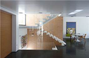 מדרגות פלדה ואבן מרחפות לצד פינת אוכל מודרנית. עיצוב: אדריכל מרק טופילסקי