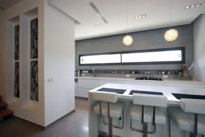 מטבח מודרני עם פינת אכילה בצבעים בהירים בתוך בית בכרכור. עיצוב:CG DESIGN - כרמית גורש עיצוב ואדריכלות פנים