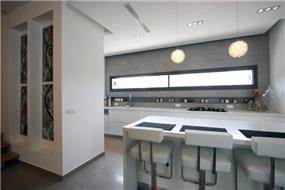 מטבח מודרני עם פינת אכילה בצבעים בהירים בתוך בית בכרכור. עיצוב:CG DESIGN - כרמית גורש עיצוב ואדריכלות פנים