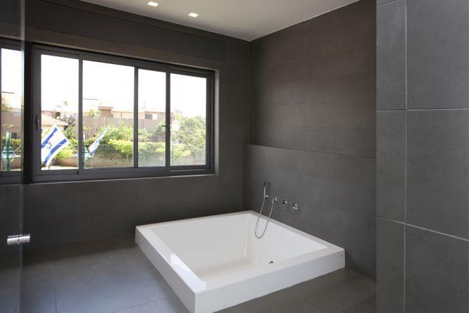 חדר אמבטיה בעיצוב מינימליסטי וריצוף כהה. עיצוב: ענבל ברקוביץ