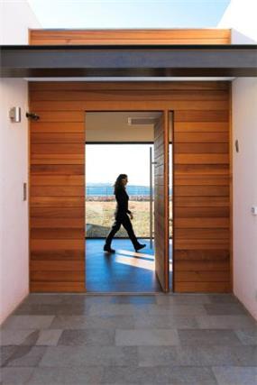 דלת כניסה מעץ ומערכת קיר מחופה עץ סביב. עיצוב saab architecs