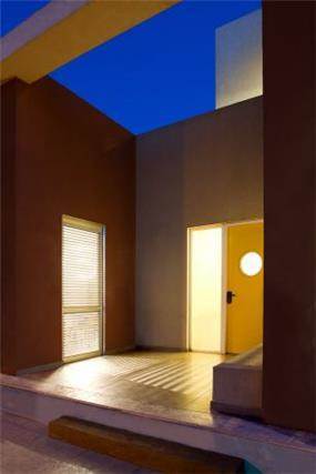 משחק של תאורה במבנה חצי סגור וחצי פתוח של כניסה לבית. עיצוב של saab architects 
