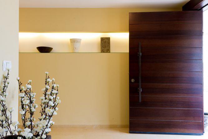 דלת כניסה מעץ "פיווט" ונישת גבס עם תאורה. עיצוב של SaaB architects