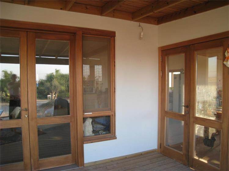 דלתות כניסה מעץ עם חלונות לכניסת אור טבעית מבית נגריית אילן